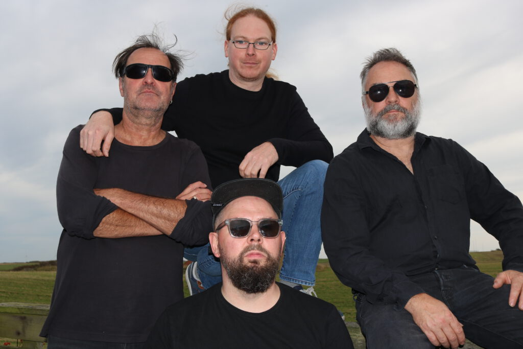 Bild der Band, vier Männer mit schwarzem Oberteil.