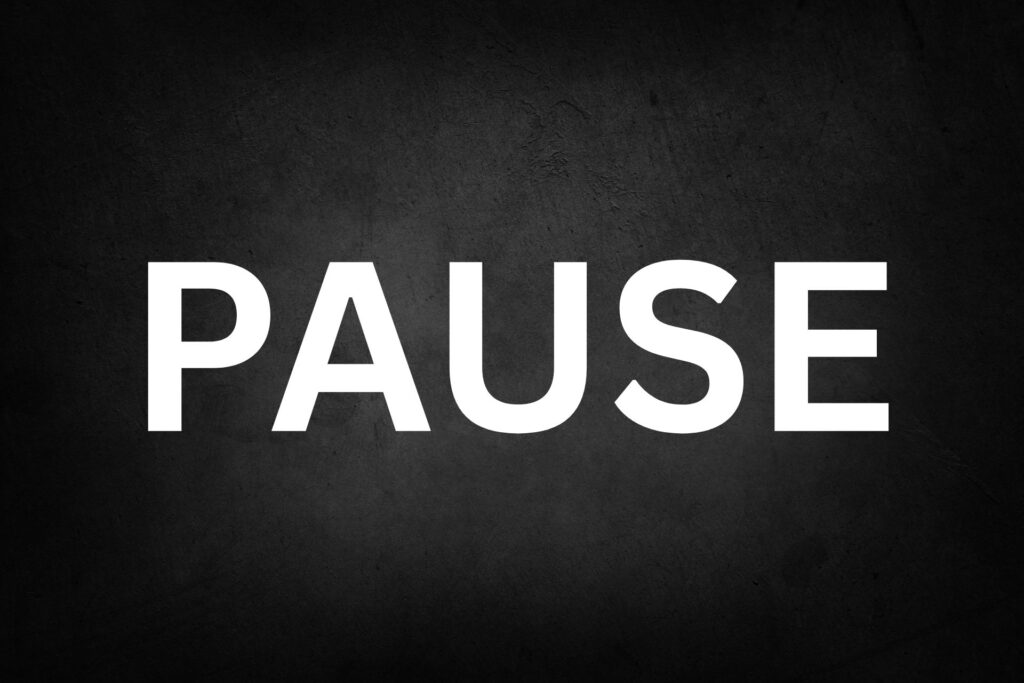 Schwarzer Hintergrund mit weißer Schrift "Pause"